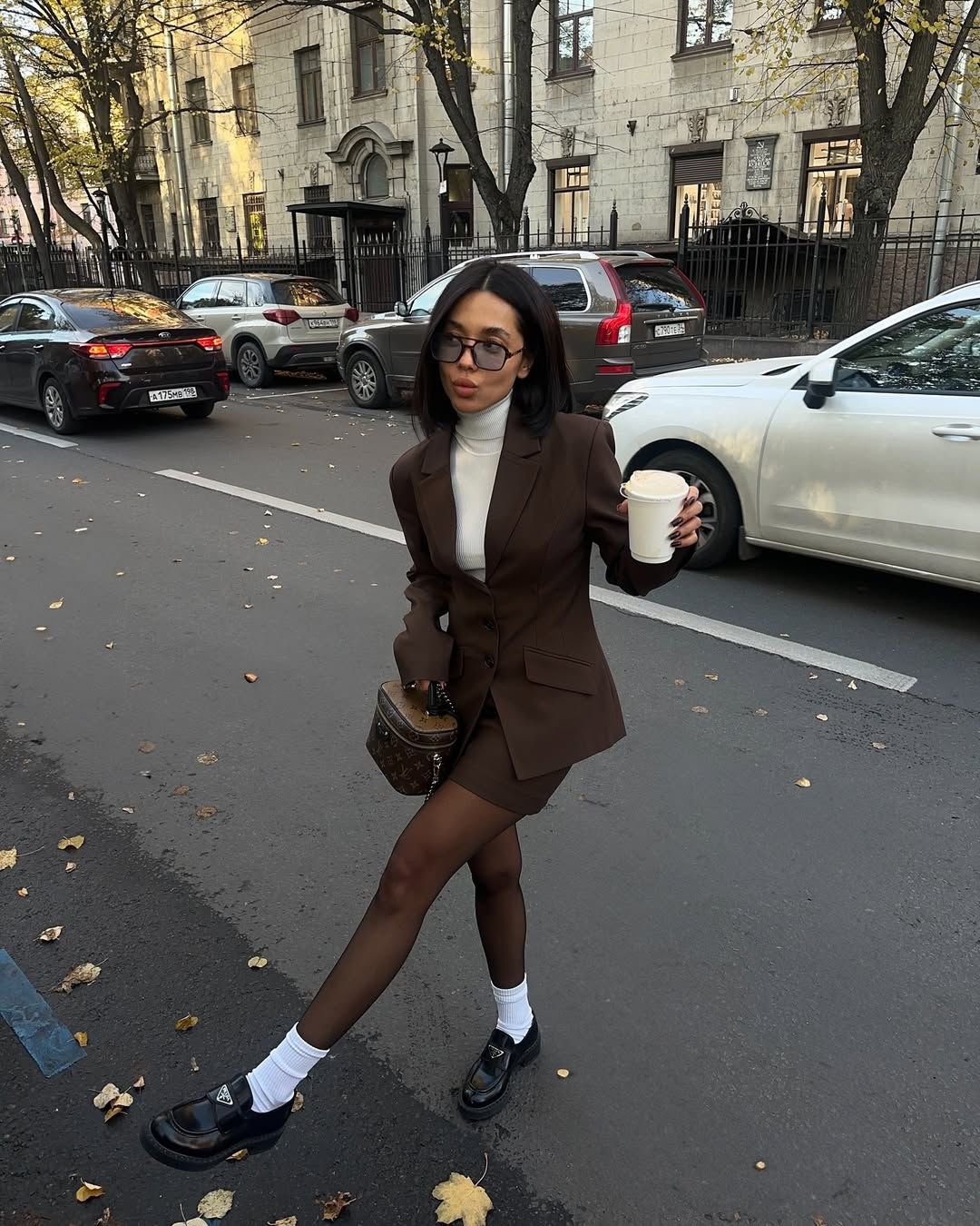 woman wearing striped sweater, white pants, yellow bag, and sunglasses